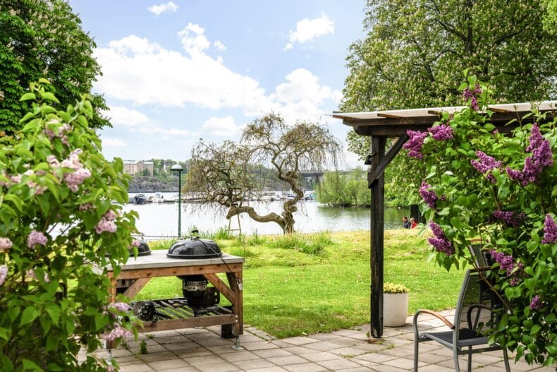 Uteplats med grill syrenträd och utsikt mot vattnet och träd