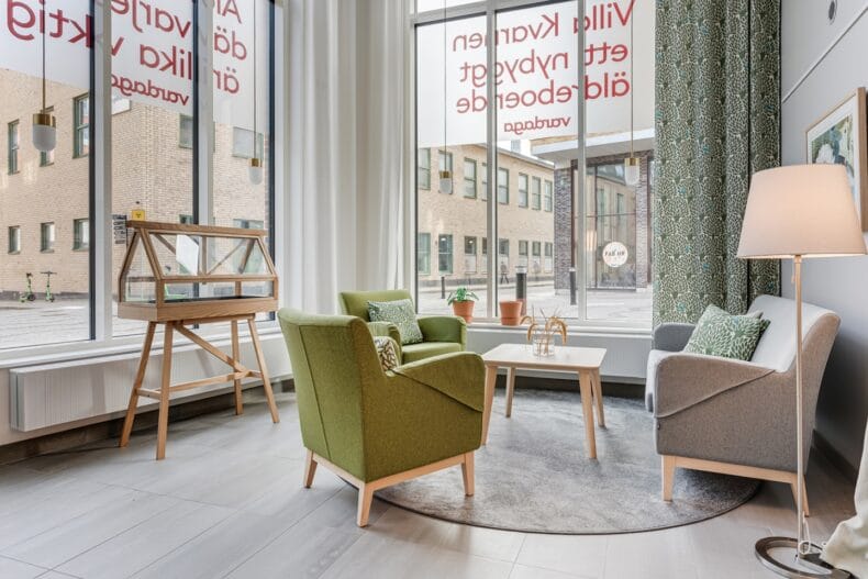 Soffhörna i gatuplan med stora fönster mot gatan utanför.