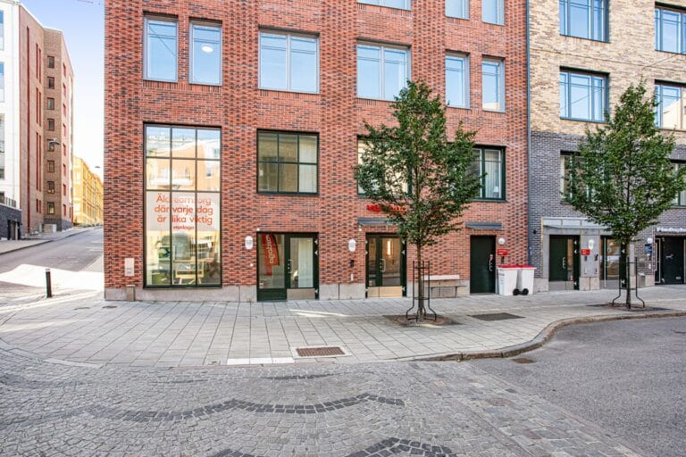 Boendets fasad i rött tegel på hörnet av ett kvarter.