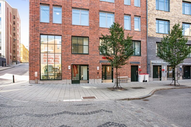 Boendets fasad i rött tegel på hörnet av ett kvarter.