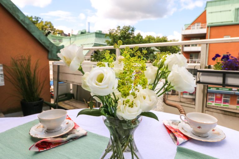 bord med vit blomma och tekoppar